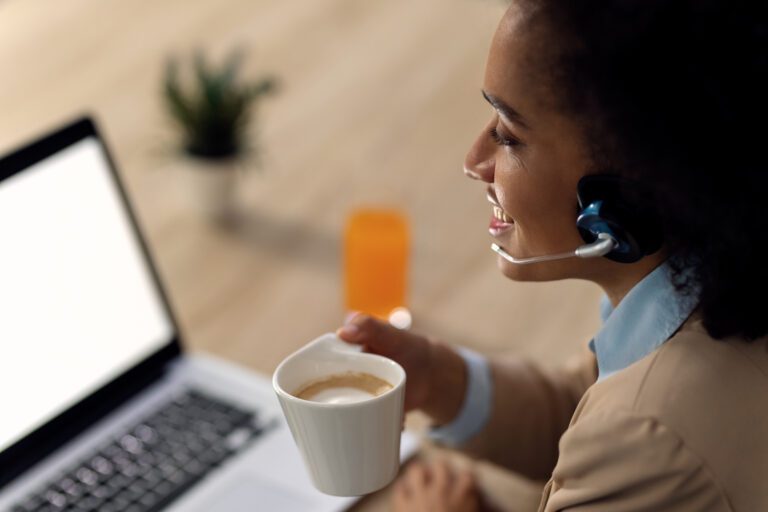 happy african american businesswoman drinking coffee conference call laptop