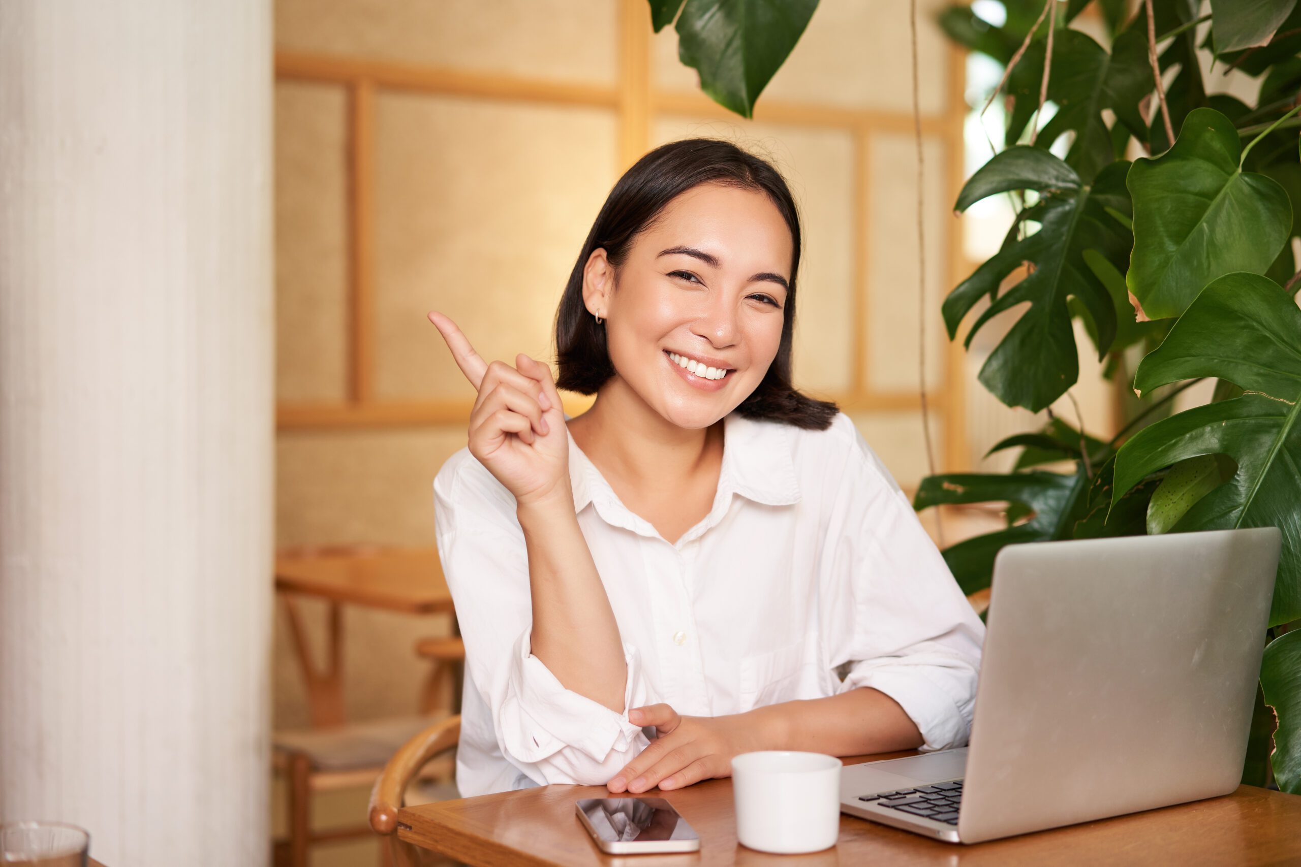 stylish young entrepreneur girl with laptop sitting cafe pointing finger advertisement banner scaled