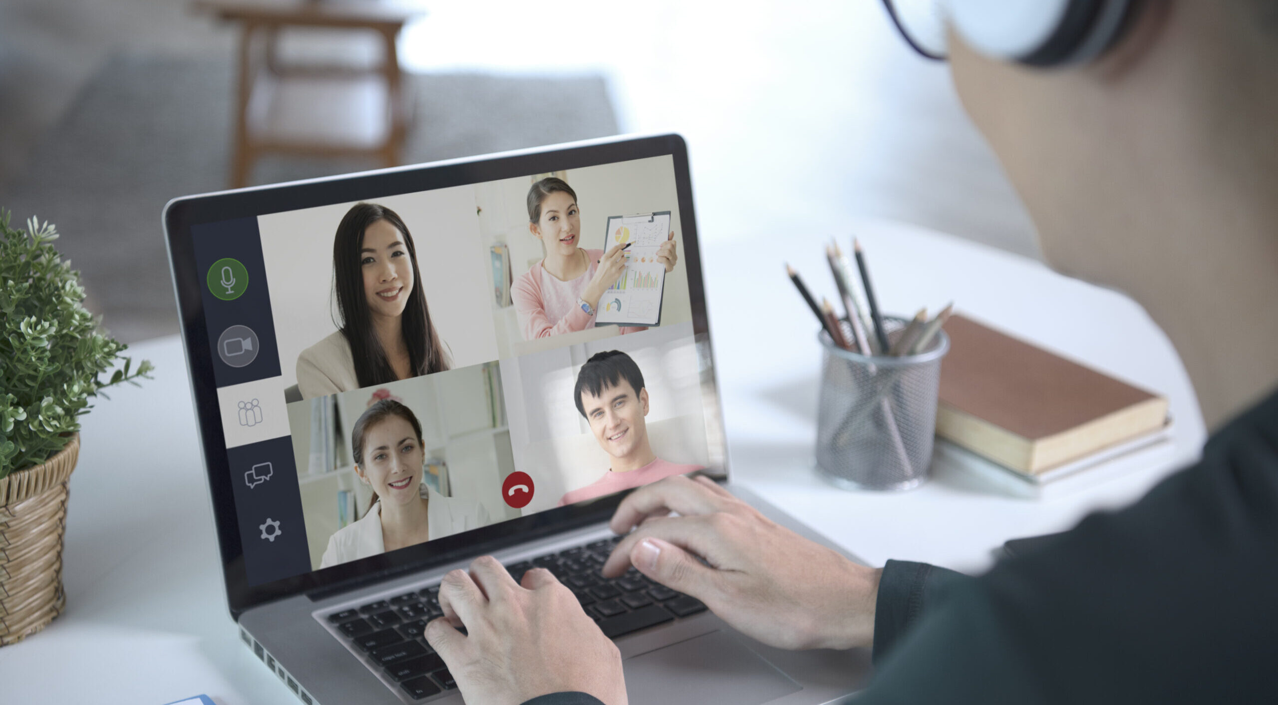 young asian businessman wear headphones working remotely from home virtual video conference meeting with colleagues business people social distancing home office concept scaled e1736793853633